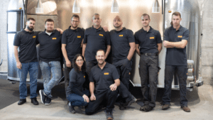 Team der Wenk AG vor einem Anhänger.